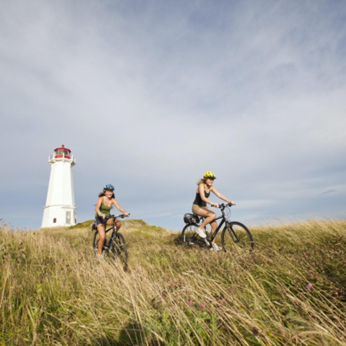 Cycling by a lighthouse on the renowned Cabot Trail!